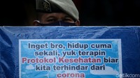 Tampak seorang petugas Satpol PP melakukan sosialisasi penerapan protokol kesehatan sebagai upaya pencegahan penyebaran virus Corona di kawasan Bundaran HI, Jakarta, Senin (30/11/2020).