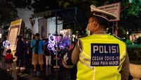 Petugas kepolisian memantau penerapan protokol kesehatan saat Operasi Yustisi COVID-19 di Kawasan Kota Lama Semarang, Jawa Tengah, Minggu (29/11/2020).