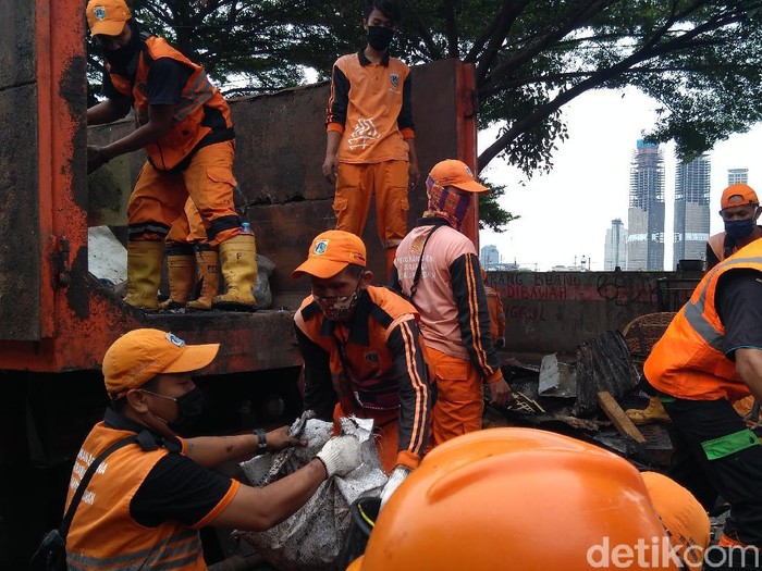 Petugas mengangkut sisa-sisa bekas kebakaran di Jalan Petamburan II, Jakarta Pusat.