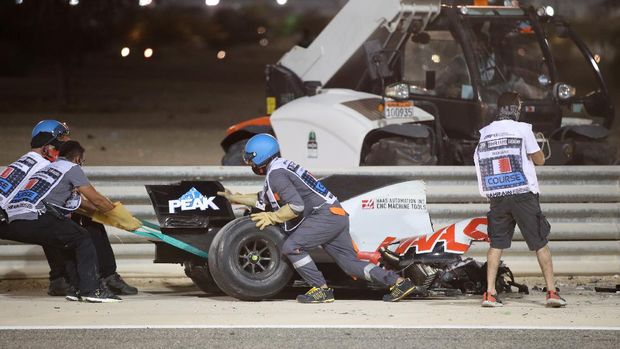 BAHRAIN, BAHRAIN - NOVEMBER 29: Track marshals clear the debris following the crash of Romain Grosjean of France and Haas F1 during the F1 Grand Prix of Bahrain at Bahrain International Circuit on November 29, 2020 in Bahrain, Bahrain. (Photo by Tolga Bozoglu - Pool/Getty Images)