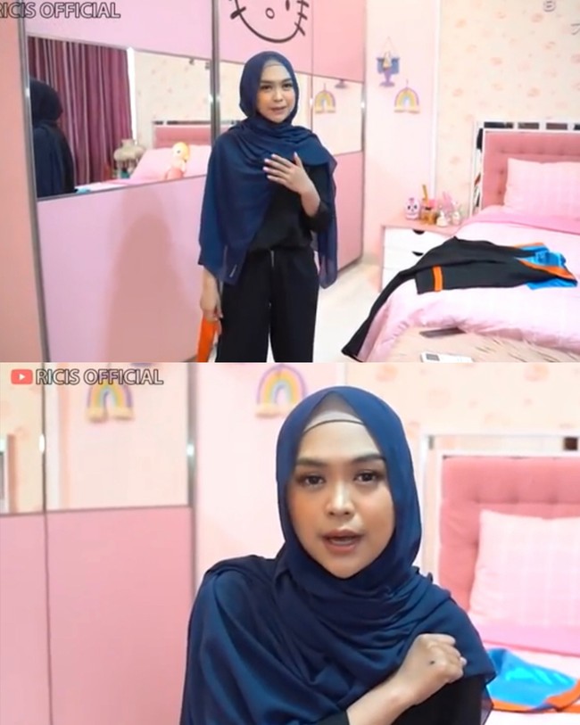 Dalam video yang berdurasi 13.41 menit itu, Ricis tampak berada di dalam kamarnya yang serba pink. Wisuda online, Ricis memakai hijab pashmina tali bahan ceruty warna navy. Ia memakai inner hijab warna mocca agar bagian rambut depannya tidak terlihat. Ricis pun tampil flawless dengan makeup yang natural. Foto: Screenshot Youtube Ricis Official.