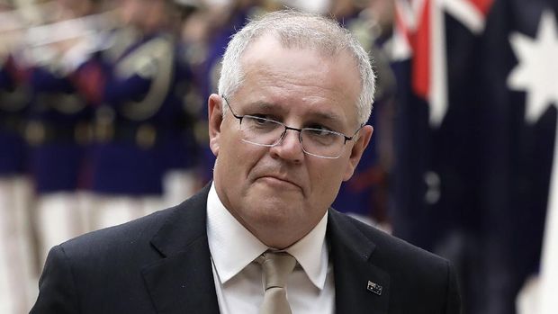 FILE - In this Nov. 17, 2020, file photo, Australian Prime Minister Scott Morrison reviews an honor guard during a ceremony ahead of a meeting at Japanese Prime Minister Yoshihide Suga's official residence in Tokyo. Morrison said Monday, Nov. 30, 2020, a tweet by a Chinese official which shows a fake image of an Australian soldier appearing to slit a child's throat is 
