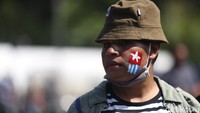 Salah satu peserta aksi menghias pipinya dengan gambar bendera bintang kejora.