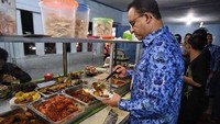 Dengan berseragam batik, Gubernur Anies Baswedan tampak serius saat mengambil lauk di warteg. Foto: Instagram @aniesbaswedan