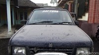 Abu vulkanik Gunung Semeru menyelimuti sebuah mobil yang terparkir di depan rumah warga.