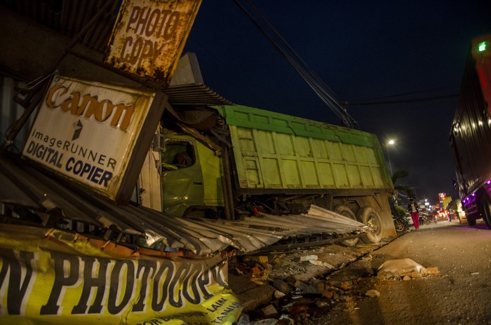 Warga melihat kondisi truk yang menabrak kios usai kecelakaan beruntun di Alun Alun Tanjungsari, Sumedang, Jawa Barat, Selasa (1/12/2020). Truk yang diduga mengalami rem blong tersebut menabrak mobil, angkot, sepeda motor, dan kios mengakibatkan sementara terdata dua orang korban meninggal dunia, satu orang luka berat, dan lima orang luka ringan. ANTARA FOTO/Novrian Arbi/hp.