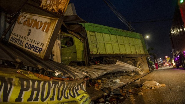 KECELAKAAN BERUNTUN DI SUMEDANG Warga melihat kondisi truk yang menabrak kios usai kecelakaan beruntun di Alun Alun Tanjungsari, Sumedang, Jawa Barat, Selasa (1/12/2020). Truk yang diduga mengalami rem blong tersebut menabrak mobil, angkot, sepeda motor, dan kios mengakibatkan sementara terdata dua orang korban meninggal dunia, satu orang luka berat, dan lima orang luka ringan. ANTARA FOTO/Novrian Arbi/hp.