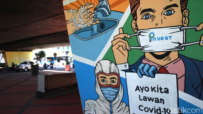 Mural COVID-19 Pengendara kendaraan bermotor melintas di depan mural himbauan untuk melawan COVID-19 di Jakarta, Selasa (1/12/2020). Mural di pilar jembatan tersebut merupakan sarana himbauan kepada warga untuk tetap menerapkan protokol kesehatan pencegahan penularan COVID-19.