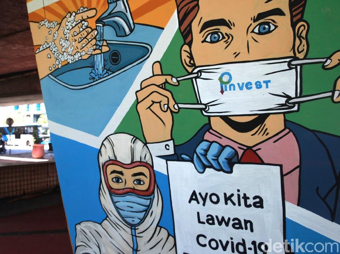 Pengendara kendaraan bermotor melintas di depan mural himbauan untuk melawan COVID-19 di Jakarta, Selasa (1/12/2020). Mural di pilar jembatan tersebut merupakan sarana himbauan kepada warga untuk tetap menerapkan protokol kesehatan pencegahan penularan COVID-19.