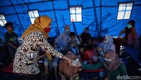 Pembaginan nasi bagi warga korban banjir di posko pengungsian.