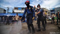 Damkar melakukan simulasi penyemprotan disinfektan di lokasi banjir.