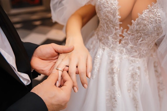 Yuri memasang cincin di jari manis Margo sebagai tanda sang boneka seks telah menjadi istrinya. (Foto: Instagram/@yurii_tolochko)