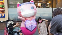 Sehari-hari Koronon dapat ditemui di sejumlah spot populer Tokyo seperti Ikebukuro dan Shinjuku. Selain mengingatkan tiap orang, Koronon juga sekaligus membagikan masker gratis (Stanislav Kogiku/Getty Images)