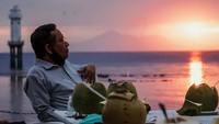 Santai sore sambil menikmati pemandangan matahari terbenam memang paling syahdu. Apalagi ditemani kelapa muda yang diseruput di pinggir pantai. Begini cara Mahfud MD melepas lelah.  Foto: instagram @mohmahfudmd