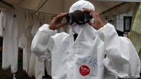 Para petugas yang melakukan proses dekontaminasi tersebut mengenakan pakaian khusus guna mencegah penyebaran virus Corona.