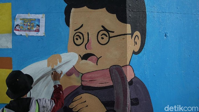 eorang seniman melukis mural di kolong Tol Wiyoto Wiyono, Jakarta Timur, Rabu (2/12/2020). Nantinya akan ada 100 tiang TOL yang akan dimural dengan gambar protokol kesehatan.