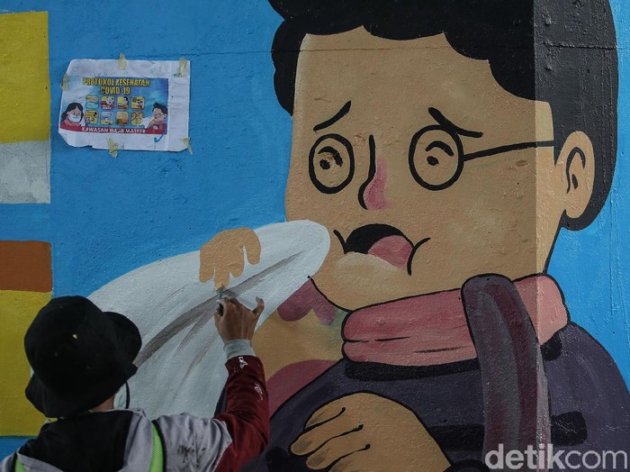 eorang seniman melukis mural di kolong Tol Wiyoto Wiyono, Jakarta Timur, Rabu (2/12/2020). Nantinya akan ada 100 tiang TOL yang akan dimural dengan gambar protokol kesehatan.