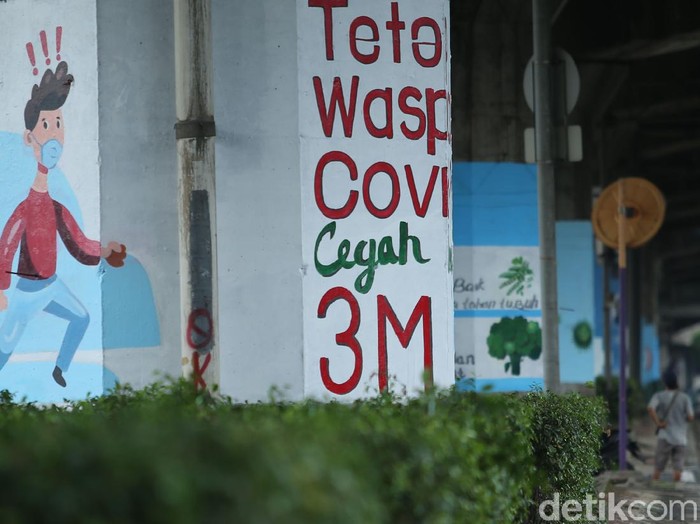 eorang seniman melukis mural di kolong Tol Wiyoto Wiyono, Jakarta Timur, Rabu (2/12/2020). Nantinya akan ada 100 tiang TOL yang akan dimural dengan gambar protokol kesehatan.