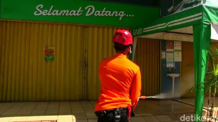 Petugas menyemprotkan cairan disinfektan di supermarket Purwakarta.