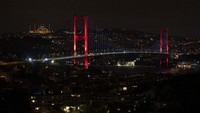 Jembatan Bosphorus tampak dari kejauhan. Hanya 1-2 mobil berseliweran di jalan saat malam datang. Meski ada lockdown dan jam malam, beberapa sektor ekonomi masih dapat izin khusus untuk terus beroperasi misalnya produksi, distribusi, kesehatan, dan pertanian. (AP/)