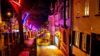 Hiasan lampu Natal bergantungan di pohon untuk menyinari jalanan yang sepi akibat pandemi di Kota Lama Marburg, Jerman. AP Photo/Michael Probst  