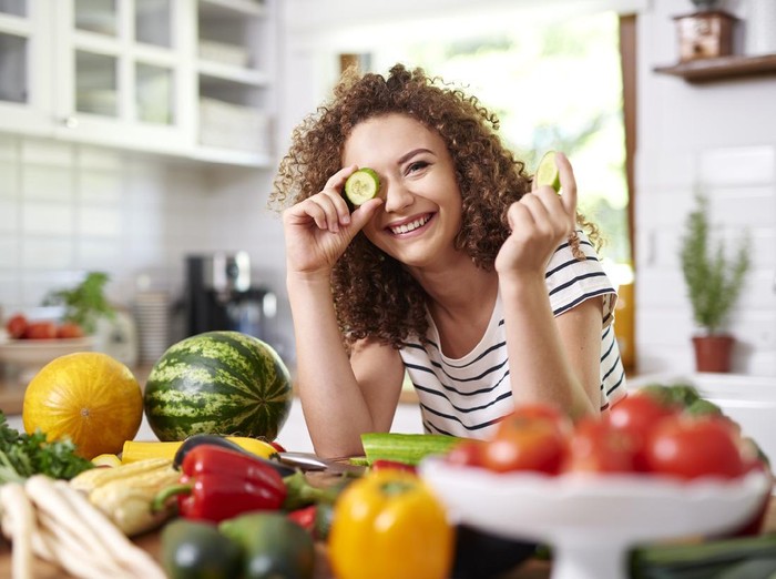 1173527649 Woman holding a slice of cucumber