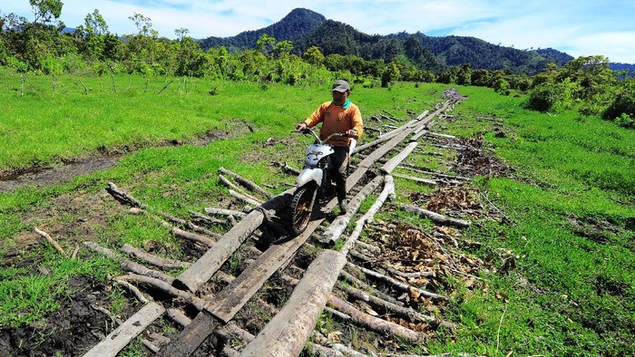 AKSES JALAN DESA TERPENCIL DI KERINCI Warga melintasi jalan penghubung Desa Renah Kasah dengan Sungai Sampun di Kayu Aro, Kerinci, Jambi, Kamis (3/12/2020). Renah Kasah yang berada di kawasan perbukitan di atas rawa dalam Danau Bento di ketinggian di atas 1300 mdpl merupakan salah satu desa terpencil dengan akses jalan penghubung yang kurang memadai. ANTARA FOTO/Wahdi Septiawan/wsj.