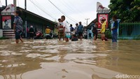 Sejumlah anak justru asyik bermain banjir.