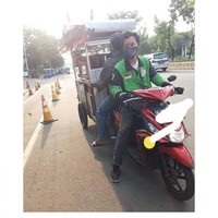 Biar nggak capai dorong gerobaknya mending naik ojek online kayak gini. Tapi duduk menghadap ke belakang kayak gitu memang nggak bikin pusing ya Pak? Foto: Instagram/@lambeonlen