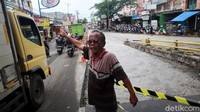 Warga membantu mengatur lalu lintas yang macet akibat proyek peninggian jalan.