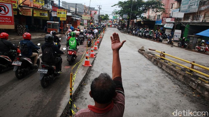 Pengendara melintasi proyek peninggian jalan untuk penanganan banjir di Jl KH Hasyim Ashari, Ciledug, Kota Tangerang, Kamis (3/12/2020). Proyek tersebut berdampak pada penyempitan jalan dan kemacetan. Kepadatan lalu-lintas hingga 800an meter di kedua arah tergantung jam sibuk lalu-lintas. Jalan ini merupakan salah satu akses dari Kota Tangerang ke Jakarta.