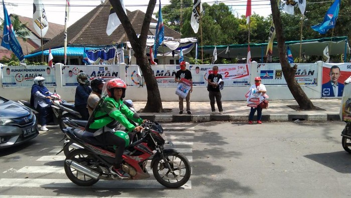 Relawan Bobby-Aulia bagikan brosur di depan posko Akhyar-Salman (Arfah-detikcom)