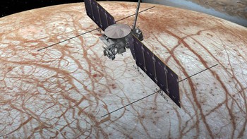 Europa diyakini merupakan dunia yang aktif secara geologi, seperti halnya Bumi. Permukaannya merupakan padang es yang sangat luas. Nah di bawah lapisan beku itu, ilmuwan mempercayai mungkin saja ada lapisan air dalam bentuk cair. Ini adalah foto ilustrasi pesawat NASA mengawasi Europa dengan Jupiter di latar belakang. Foto: NASA