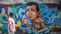 Warga melintas di depan grafiti Tumbang di kawasan Cikini, Jakarta Pusat, Jumat (4/12/2020).