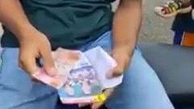 Video pemuda buka amplop isi duit bergambar foto paslon Pilkada Gunungkidul viral.