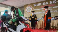 Farhan yang dikenal akrab oleh dosen dan mahasiswa sebagai driver ojek online tersebut bangga menghadiri wisuda dengan mengenakan seragam ojol.