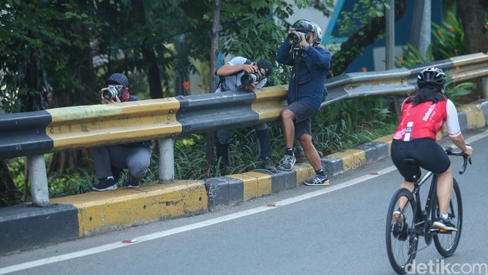 Penasaran kenapa foto para pesepeda keren-keren? Ini dia sosok-sosok fotografer yang rela rebahan di jalan hingga ngumpet di semak-semak dan pembatas jalan.