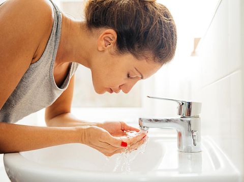Girl with towel is lookin in a mirror
