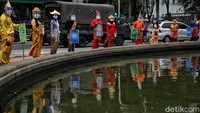 Mereka membawa sejumlah poster bertuliskan ajakan ke TPS hingga pemakaian masker.
