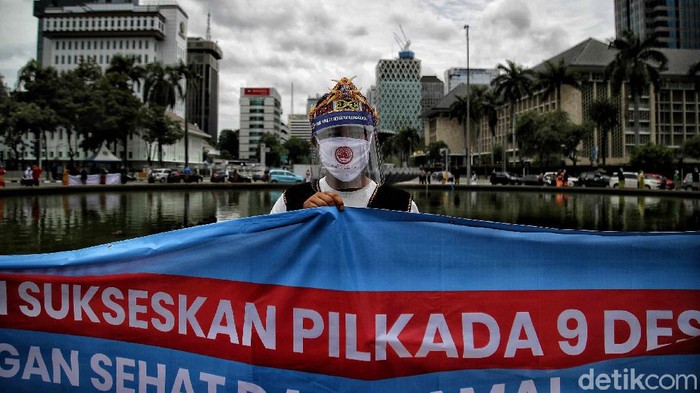Sejumlah warga yang tergabung dalam Perkumpulan Gerakan Kebangsaan melakukan Aksi Sosialisasi Sukseskan Pilkada  2020 di kawasan Monas, Jakarta Pusat, Senin (7/12). Kegiatan sosialiasi suksekan Pilkada yang dilakukan dengan atribut pakaian adat dengan bahasa daerah itu bertujuan untuk mensukseskan Pilkada 2020 serentak di 270 daerah agar berjalan tertib dan damai serta menerapkan protokol kesehatan pada 9 Desember mendatang