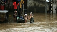 Sejumlah anak mandi di bantaran sungai yang terendam banjir.