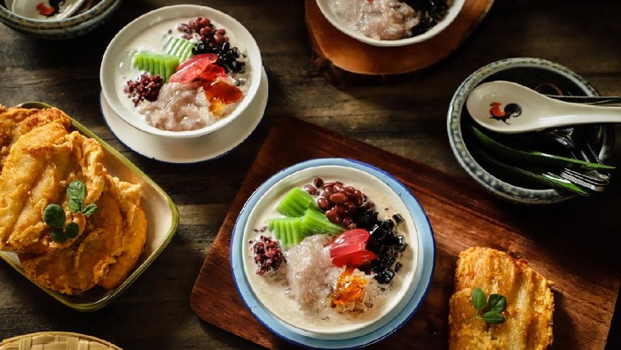 Che Hun Tiau, an icy dessert of Tapioca Cendol (noodle jelly) from Pontianak, West Kalimantan. The cendol is accompanied with Ketan Hitam (black glutinous rice), Bongko (pandan mung bean cake), Kacang Merah (red bean), Kolang Kaling (palm fruit) and Cincao (grass jelly) in coconut milk soup sweetened with palm sugar syrup. This dessert dish is plated in a ceramic bowl with an underliner plate and served accompanied with fried bananas.