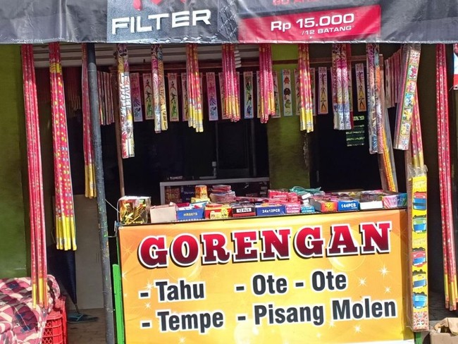 Di spanduknya sih tulisannya gorengan, tapi yang dijual kok petasan ya bund? Mungkin gorengannya disembunyikan, kalau ada yang mau beli baru dikeluarkan. Foto: Twitter/@nocontextwarung