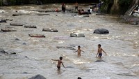 Sejumlah anak bermain di aliran sungai Ciliwung, Kota Bogor, Jawa Barat, Senin (7/12/2020).   