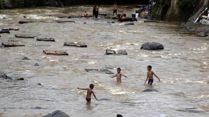 Sejumlah anak bermain di aliran sungai Ciliwung, Kota Bogor, Jawa Barat, Senin (7/12/2020). Minimnya ruang bermain menjadi salah satu alasan anak-anak bermain di tempat berbahaya seperti di Sungai Ciliwung yang arusnya deras saat musim hujan. ANTARA FOTO/Yulius Satria Wijaya/rwa.