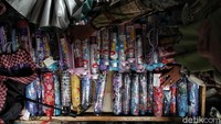 Pedagang merapikan payung di kiosnya kawasan Pasar Asemka, Jakarta. 