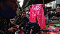 Sejumlah warga memilih jas hujan dan payung yang akan dibelinya di kawasan Pasar Asemka.