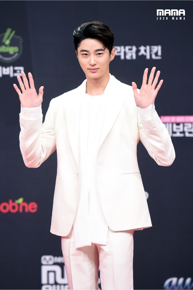 Byun Woo SeokBerbeda dengan kebanyakan aktor yang tampil klasik dengan warna hitam, Byun Woo Seok yang bermain dalam drama Record of Youth memilih berpakaian serba putih. Ketampanan aktor dan model itu pun semakin menarik atensi.  Foto: Twitter @MnetMAMA