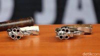 Polisi mengamankan dua pucuk pistol revolver dan sejumlah butir peluru.