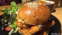 Selain croffle, kamu bisa cicip menu lain di sini. Salah satunya burger dengan patty ayam goreng tepung berbalut bumbu Korea. Foto: detikFood